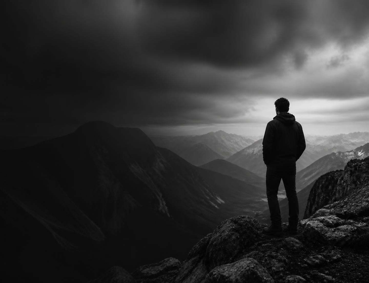 A person standing on a mountain ridge, looking into the distance